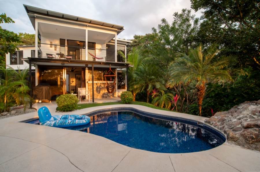 Casa Sol and its curved pool in the garden at dusk