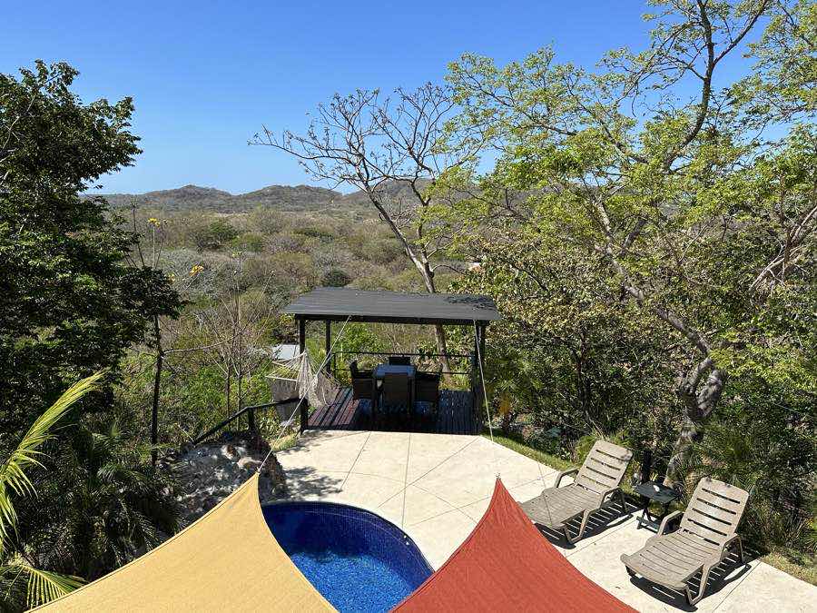 The pool deck and dining pergola at Casa Sol looking out to the hills